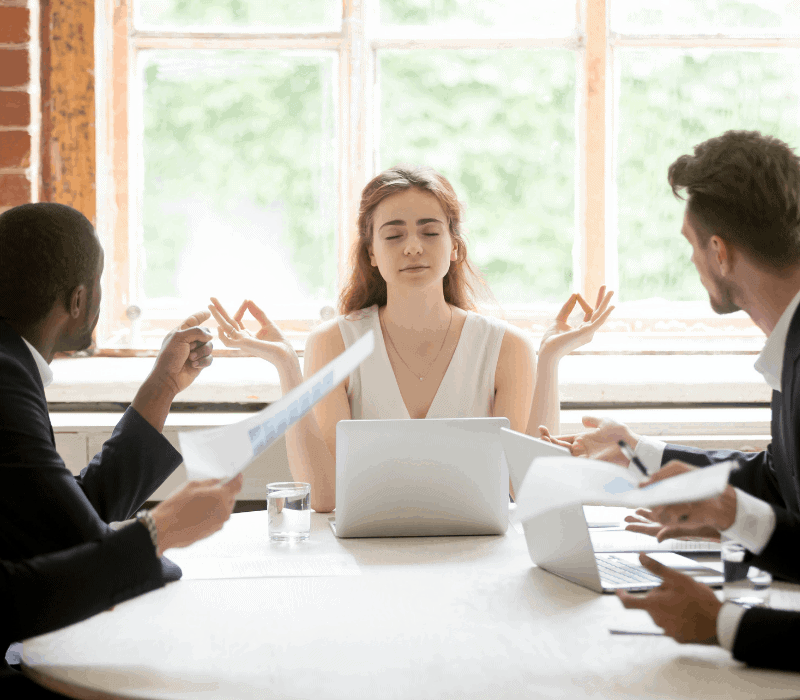 Even the best leaders derail. Woman at boardroom table meditating.