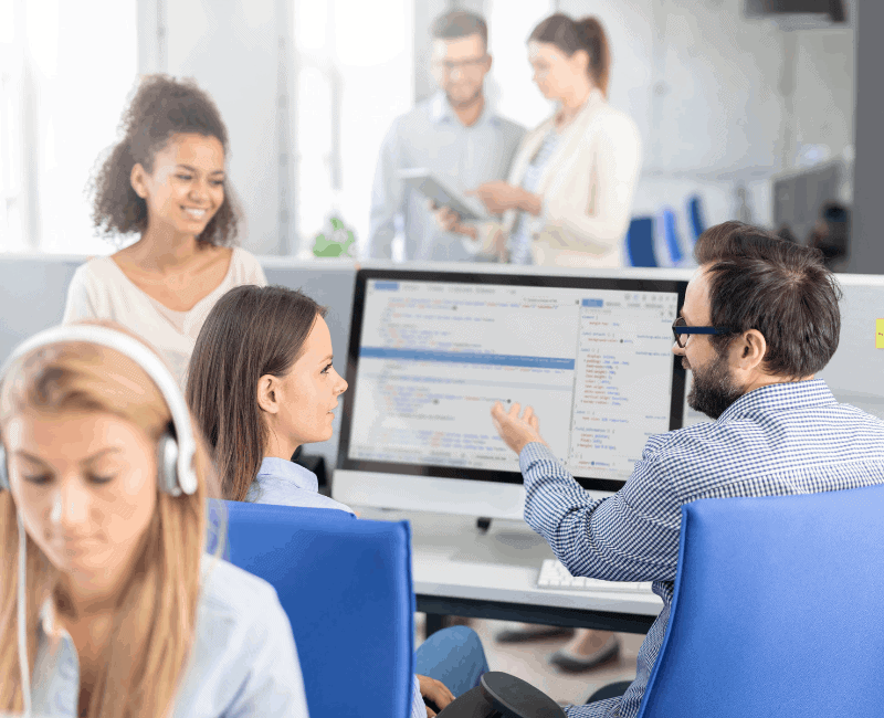 Leadership Development and positive impact. Man and two women working at computer.